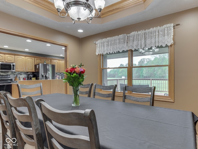 dining area with a chandelier, recessed lighting, crown molding, and a raised ceiling