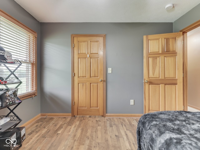 bedroom with light wood-style flooring and baseboards