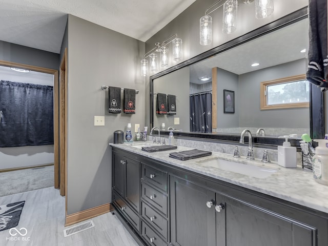 full bath with baseboards and double vanity