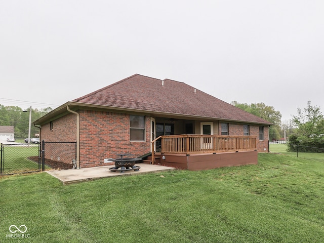 back of property featuring brick siding, a wooden deck, a patio, and a gate