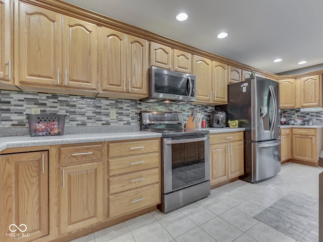 kitchen featuring appliances with stainless steel finishes, decorative backsplash, light tile patterned floors, light countertops, and recessed lighting