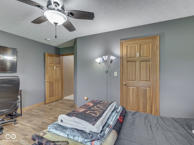 bedroom with light wood-style flooring, baseboards, and a ceiling fan