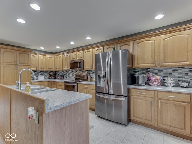 kitchen featuring stainless steel appliances, a sink, light tile patterned floors, decorative backsplash, and recessed lighting