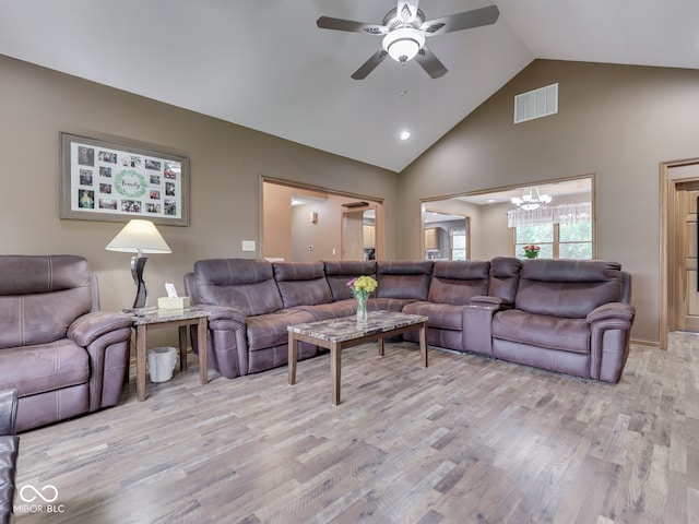 living area featuring light wood-type flooring, high vaulted ceiling, ceiling fan, a chandelier, and recessed lighting