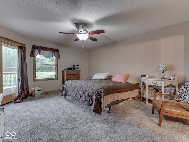 carpeted bedroom featuring access to outside, a ceiling fan, and baseboards