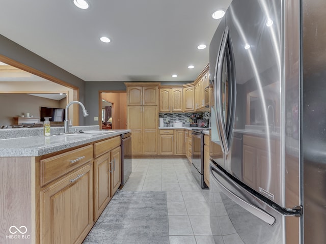 kitchen featuring appliances with stainless steel finishes, a sink, light countertops, light tile patterned flooring, and light brown cabinets