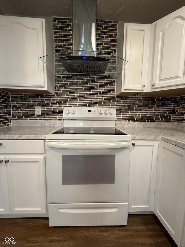 kitchen featuring electric stove, wall chimney exhaust hood, white cabinets, dark wood-type flooring, and tasteful backsplash