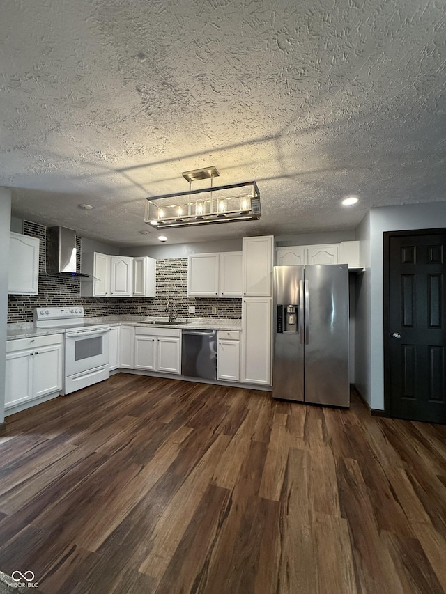 kitchen with stainless steel appliances, a textured ceiling, white cabinets, dark wood-style flooring, and decorative backsplash