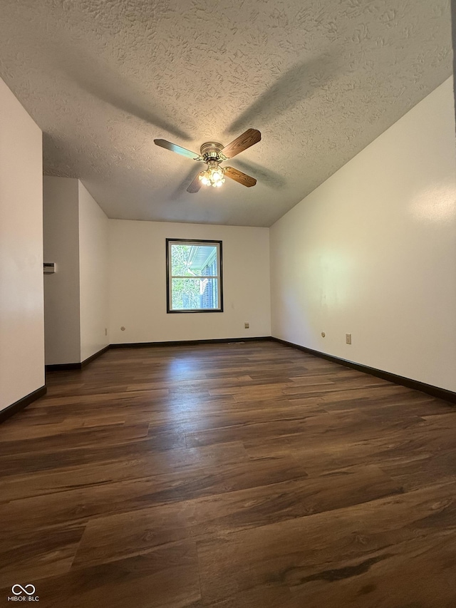 unfurnished room with a ceiling fan, dark wood finished floors, a textured ceiling, and baseboards