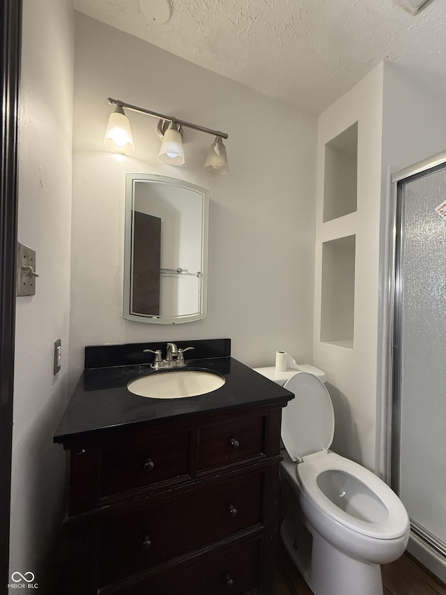 bathroom with vanity, a textured ceiling, and toilet