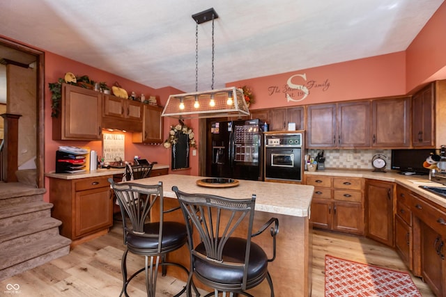 455 E Main St, Danville, IN 46122 - kitchen with black appliances, light wood-style flooring, light countertops, and a kitchen island