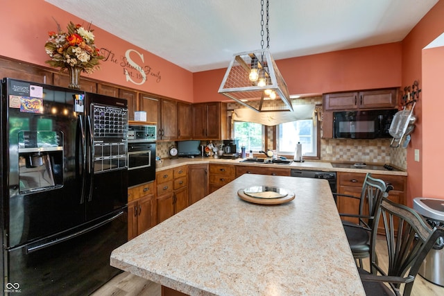455 E Main St, Danville, IN 46122 - kitchen with black appliances, light countertops, decorative backsplash, a center island, and pendant lighting
