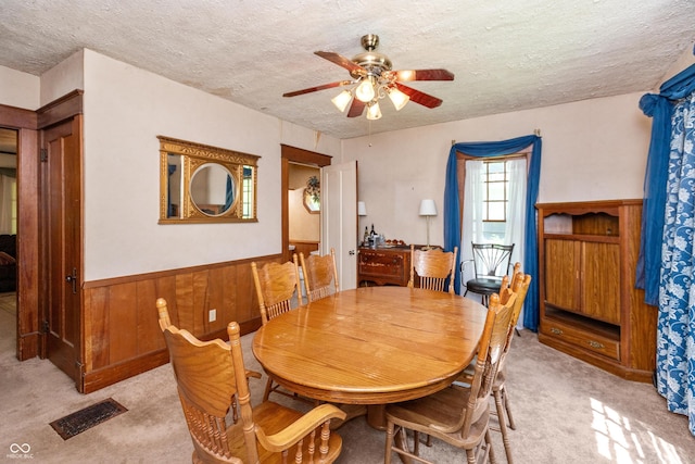 455 E Main St, Danville, IN 46122 - dining area featuring light carpet, a ceiling fan, wainscoting, a textured ceiling, and wooden walls