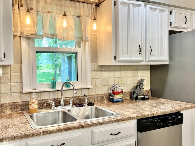 kitchen with stainless steel dishwasher, a sink, white cabinetry, light countertops, and backsplash