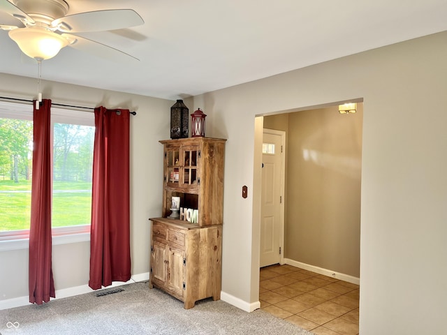 unfurnished room featuring ceiling fan, baseboards, and light tile patterned floors