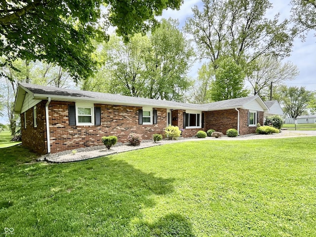 ranch-style house featuring brick siding and a front yard
