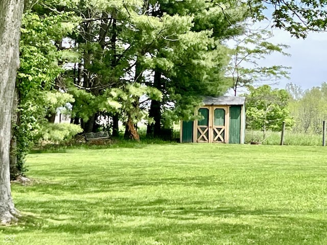 view of green lawn with a storage shed and an outdoor structure