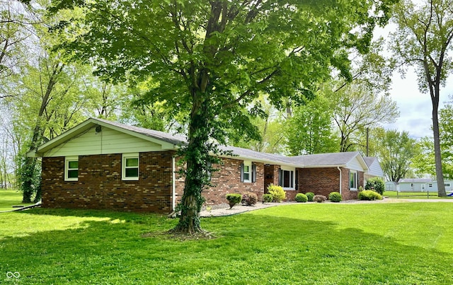 ranch-style house with a front lawn and brick siding