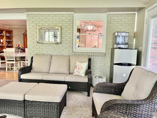 living room featuring brick wall and wood finished floors