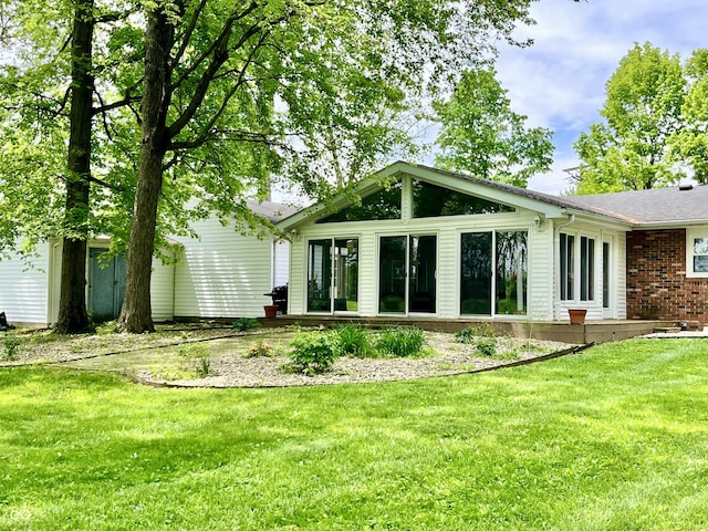 back of house with a lawn and brick siding