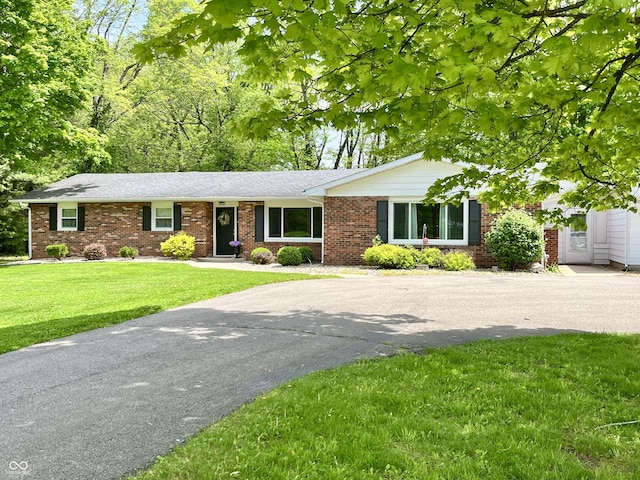 single story home with brick siding, driveway, and a front yard