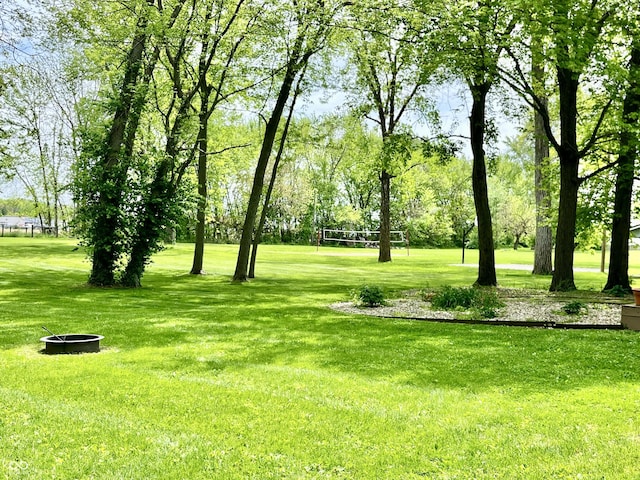 view of green lawn featuring volleyball court