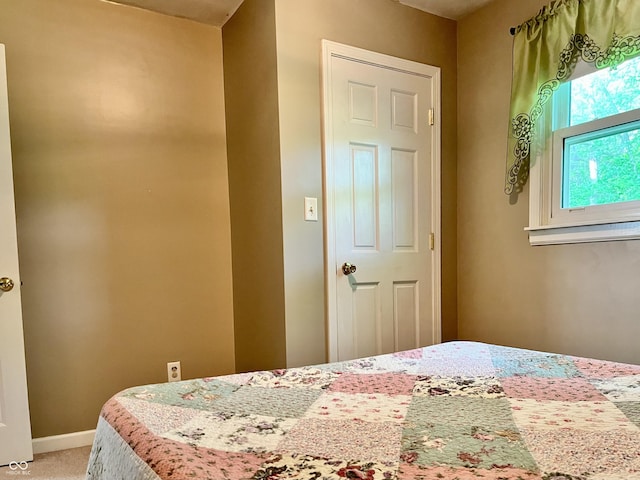 bedroom with light colored carpet and baseboards
