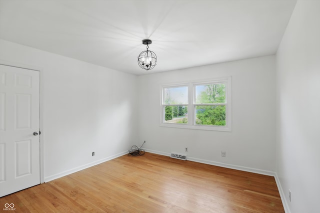 6825 Farmleigh Dr, Indianapolis, IN 46220 - empty room with light wood-style floors, baseboards, and a chandelier