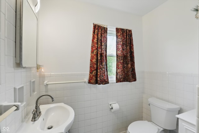 6825 Farmleigh Dr, Indianapolis, IN 46220 - bathroom with tile walls, a sink, toilet, and wainscoting