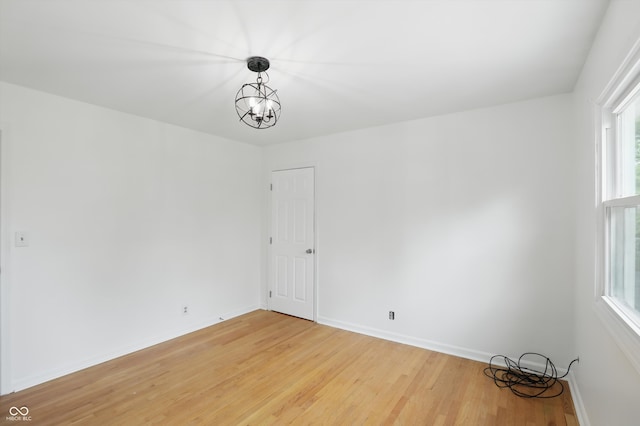 6825 Farmleigh Dr, Indianapolis, IN 46220 - spare room with light wood finished floors, a chandelier, healthy amount of natural light, and baseboards