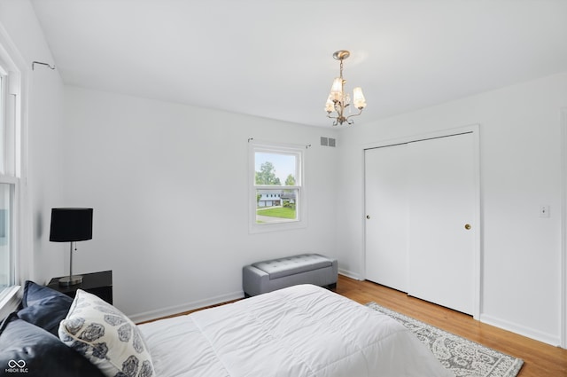6825 Farmleigh Dr, Indianapolis, IN 46220 - bedroom featuring a chandelier, wood finished floors, a closet, and baseboards