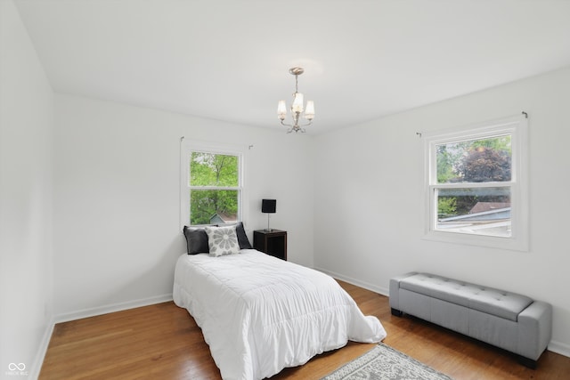 6825 Farmleigh Dr, Indianapolis, IN 46220 - bedroom with a chandelier, wood finished floors, and baseboards