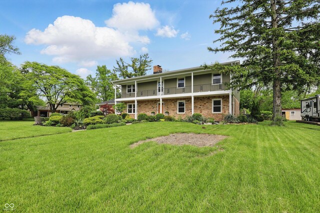 6825 Farmleigh Dr, Indianapolis, IN 46220 - back of house featuring a chimney, brick siding, a yard, and a balcony