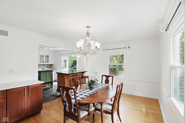 6825 Farmleigh Dr, Indianapolis, IN 46220 - dining room with plenty of natural light, a chandelier, light wood-style flooring, crown molding, and baseboards