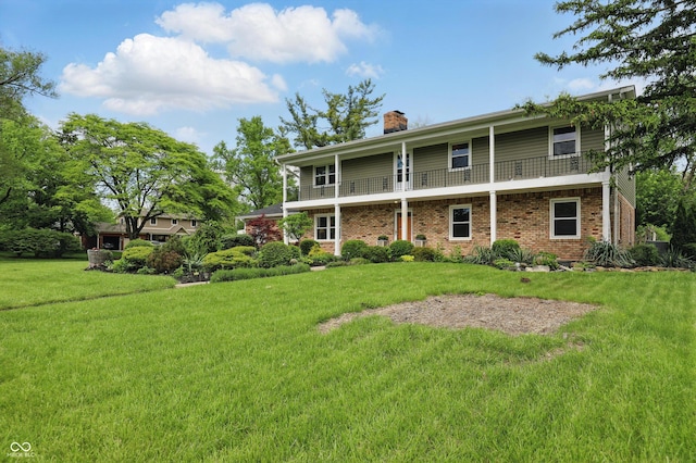 6825 Farmleigh Dr, Indianapolis, IN 46220 - back of house with a balcony, a chimney, a lawn, and brick siding