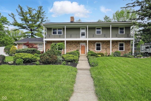 6825 Farmleigh Dr, Indianapolis, IN 46220 - view of front of home featuring a chimney, a front yard, brick siding, and a balcony