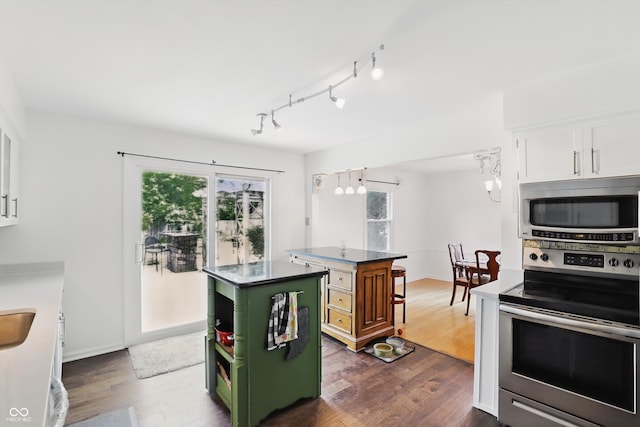 6825 Farmleigh Dr, Indianapolis, IN 46220 - kitchen featuring stainless steel appliances, a center island, dark wood finished floors, white cabinetry, and baseboards