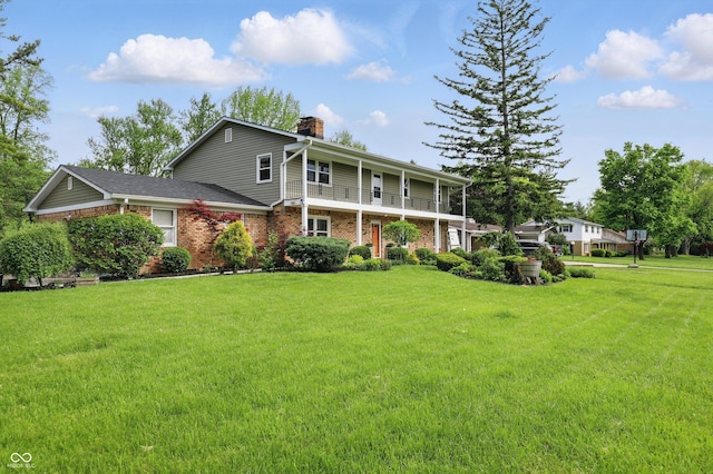 6825 Farmleigh Dr, Indianapolis, IN 46220 - view of front of property with a chimney, a front lawn, brick siding, and a balcony