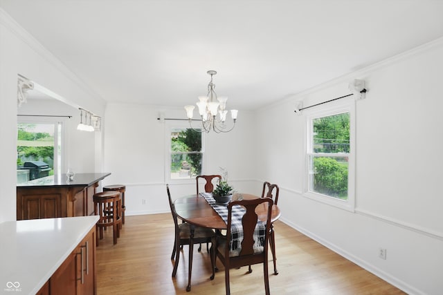 6825 Farmleigh Dr, Indianapolis, IN 46220 - dining area with light wood-type flooring, crown molding, a chandelier, and baseboards