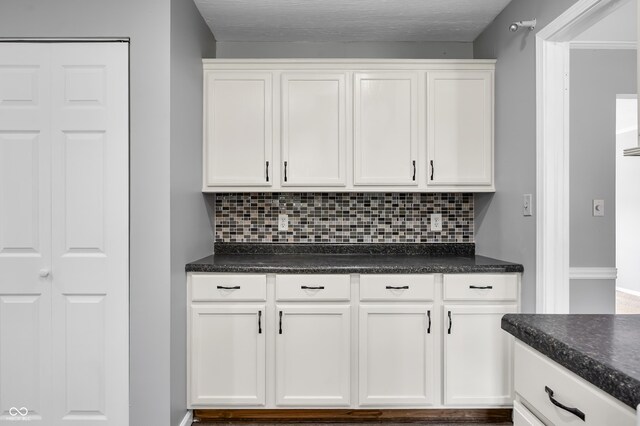 kitchen featuring dark countertops and tasteful backsplash