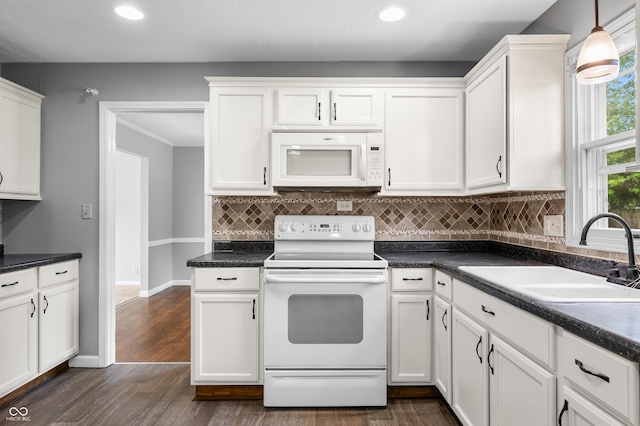 kitchen featuring white appliances, a sink, dark countertops, white cabinetry, and decorative backsplash