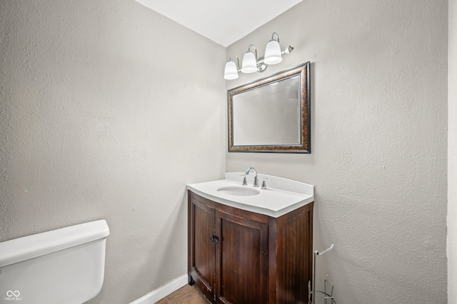 bathroom featuring vanity, toilet, and baseboards