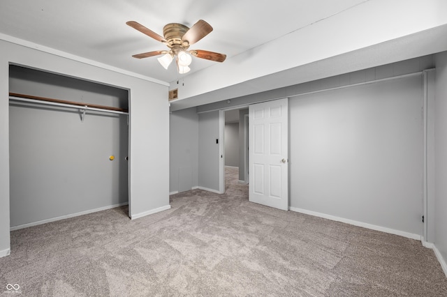 unfurnished bedroom featuring carpet flooring, a closet, baseboards, and a ceiling fan