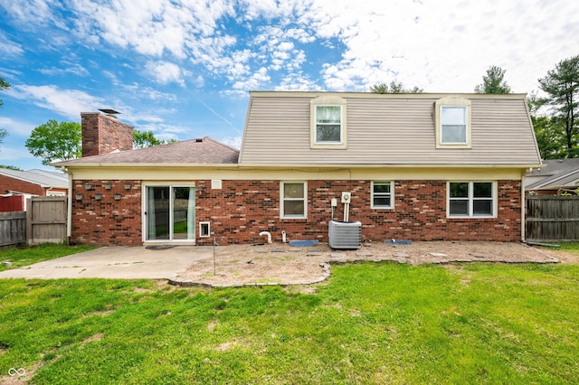 back of property featuring a patio area, brick siding, a chimney, and central AC