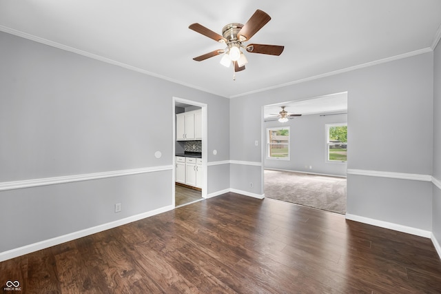 spare room featuring ceiling fan, ornamental molding, baseboards, and dark wood finished floors