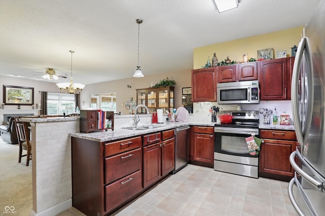 1663 Sweetgum Dr, Greenwood, IN 46143 - kitchen featuring stainless steel appliances, a sink, reddish brown cabinets, and a peninsula
