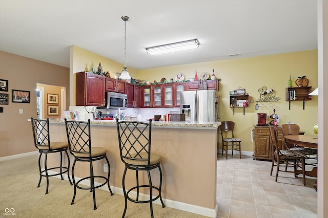 1663 Sweetgum Dr, Greenwood, IN 46143 - kitchen featuring appliances with stainless steel finishes, dark brown cabinets, a peninsula, and a kitchen bar