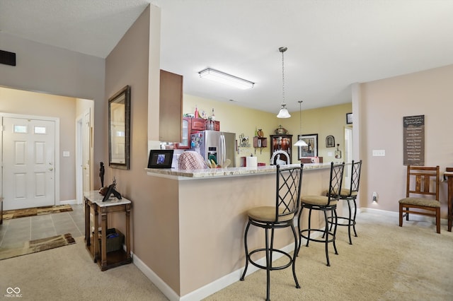 1663 Sweetgum Dr, Greenwood, IN 46143 - kitchen featuring stainless steel fridge, light carpet, a breakfast bar area, and baseboards
