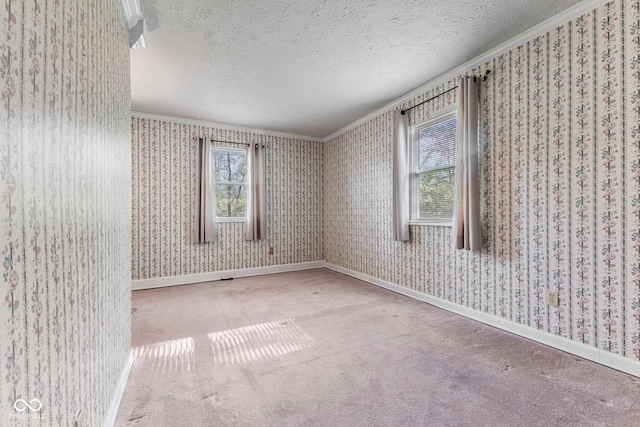 carpeted empty room featuring ornamental molding, a textured ceiling, wallpapered walls, and baseboards