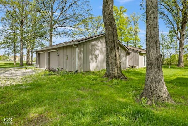 view of side of home featuring a detached garage and a yard